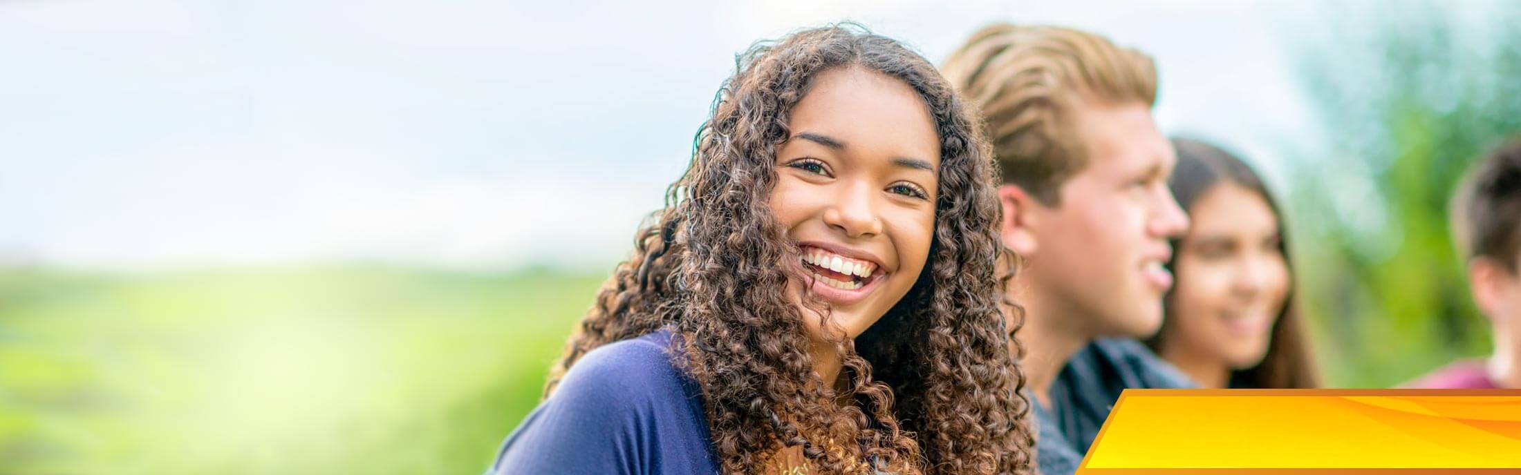 A smiling teenage girl socializes with her friends.